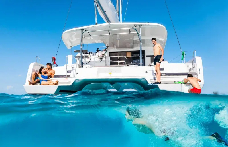 Top 10 luxury yachts for charter highlighted with a family-friendly catamaran cruising in the Caribbean’s clear waters.
